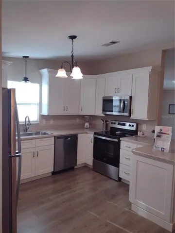 a kitchen with a table chairs refrigerator and cabinets