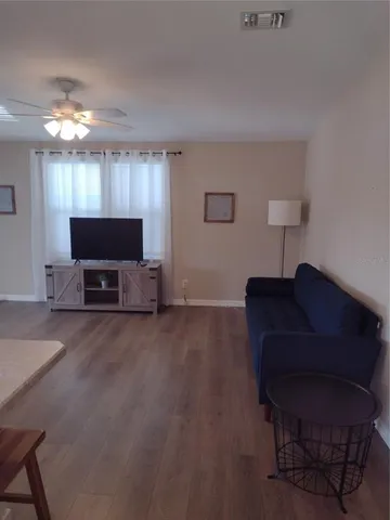 a living room with furniture and wooden floor