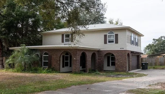 a view of a yard in front of a house with large windows