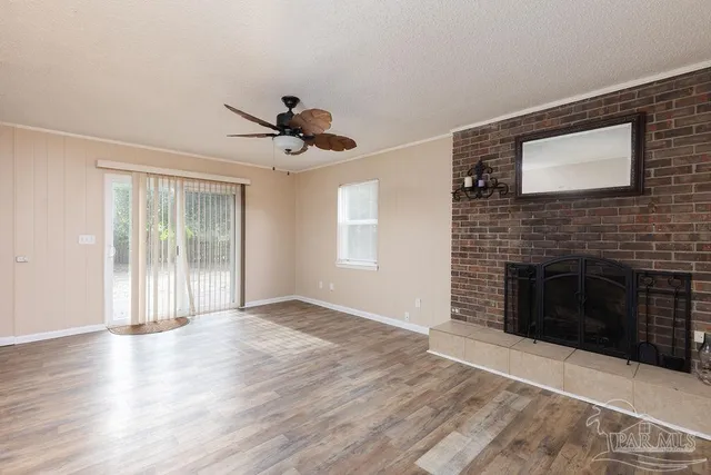 a view of an empty room with a fireplace and a window