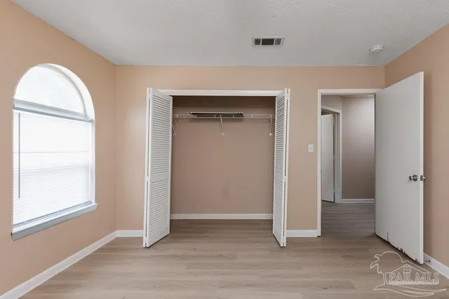 an empty room with windows and closet