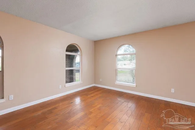 an empty room with wooden floor and a window