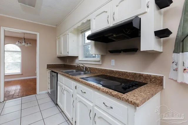 a kitchen with granite countertop a sink a stove and cabinets
