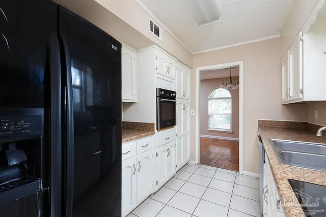a kitchen with granite countertop a refrigerator a stove and cabinets