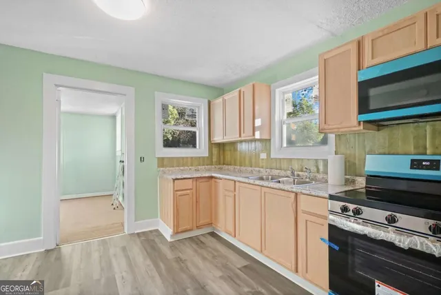 a kitchen with stainless steel appliances granite countertop a sink and a stove top oven