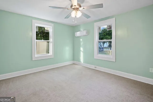 an empty room with a window and a fan