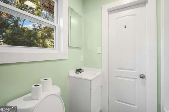 a bathroom with a toilet sink and mirror
