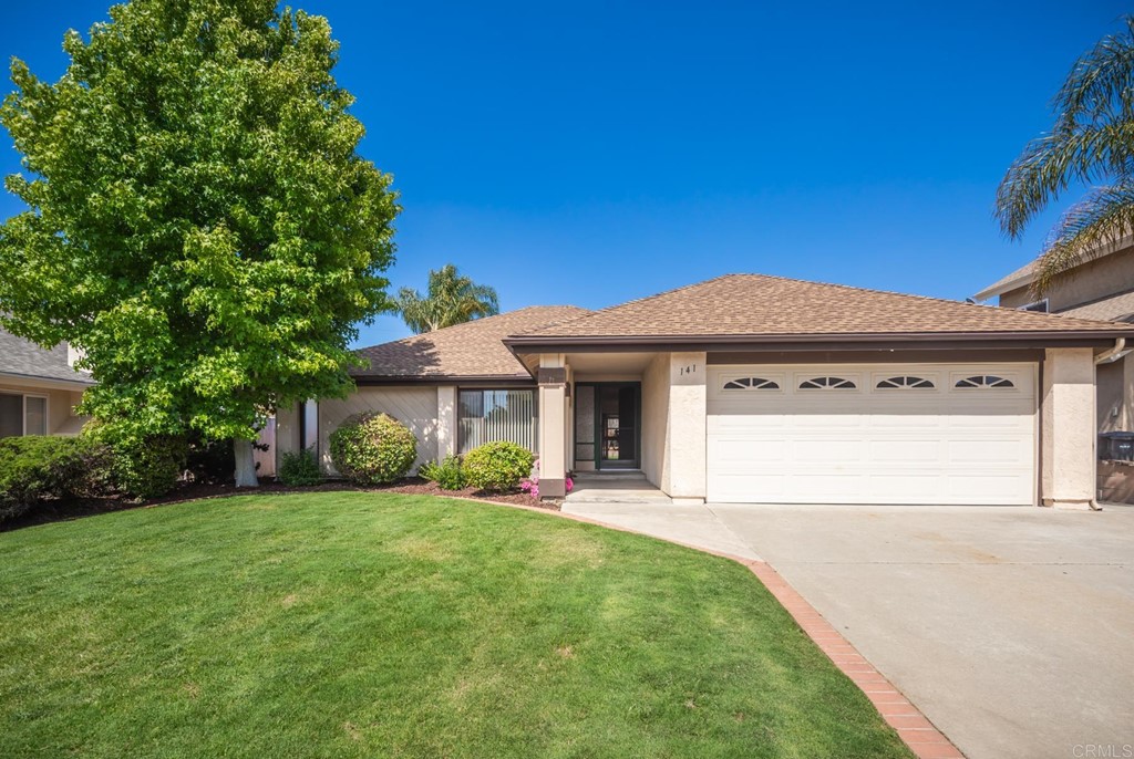 141 Solace Court Encinitas, CA 92024 - Photo 2 of 19 a front view of a house with a yard and garage