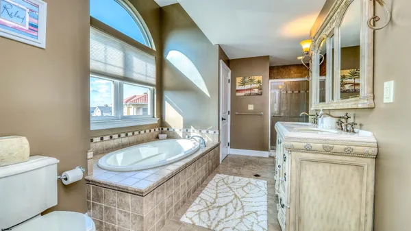 a bathroom with a granite countertop sink a toilet a mirror and shower