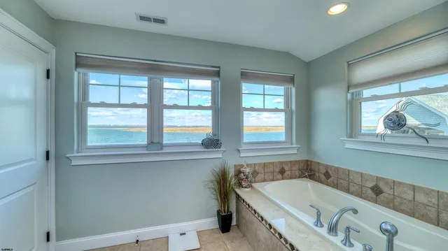 a bathroom with a tub a sink and a window