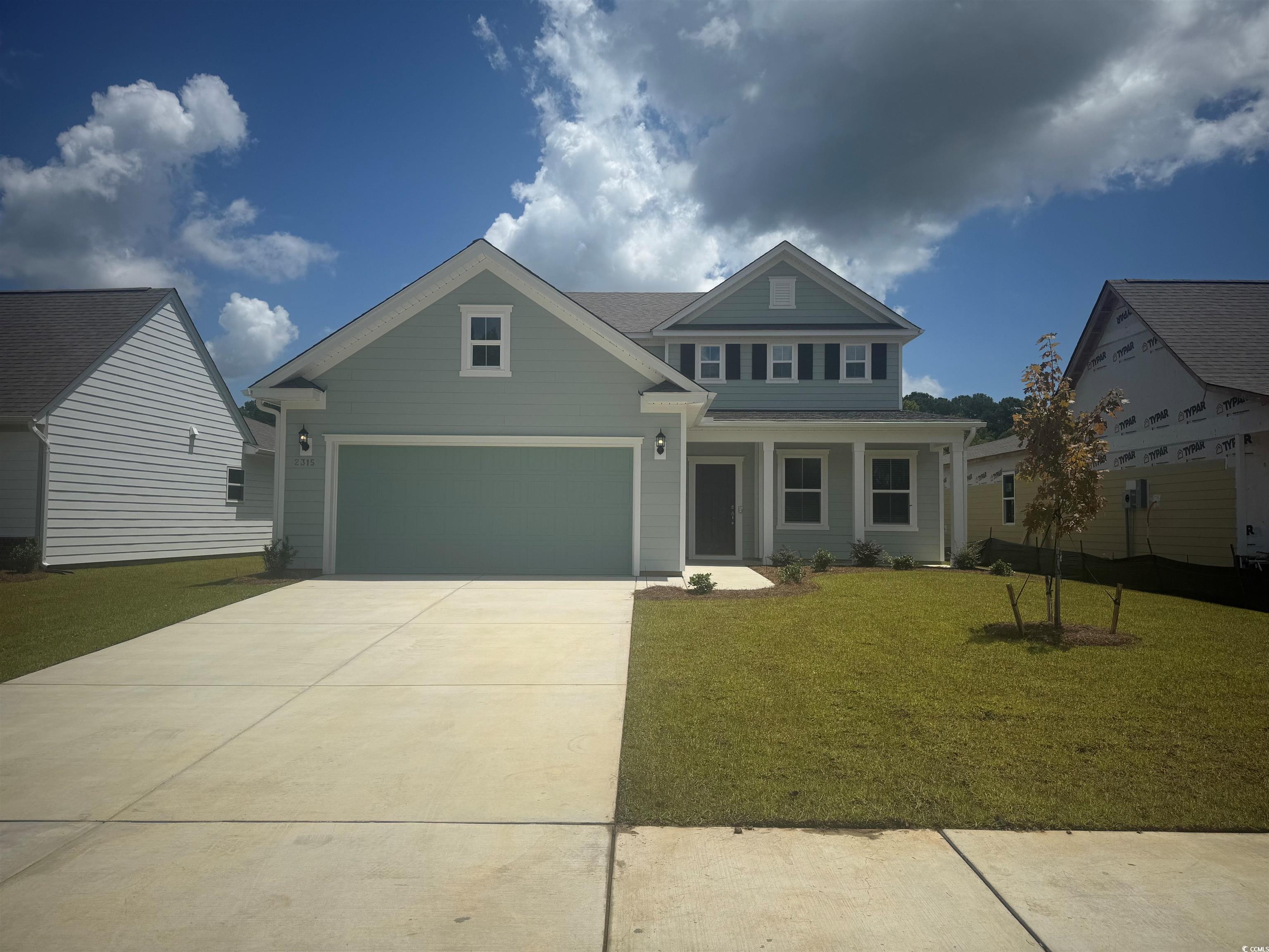 Craftsman-style house featuring a porch, a front yard, and driveway