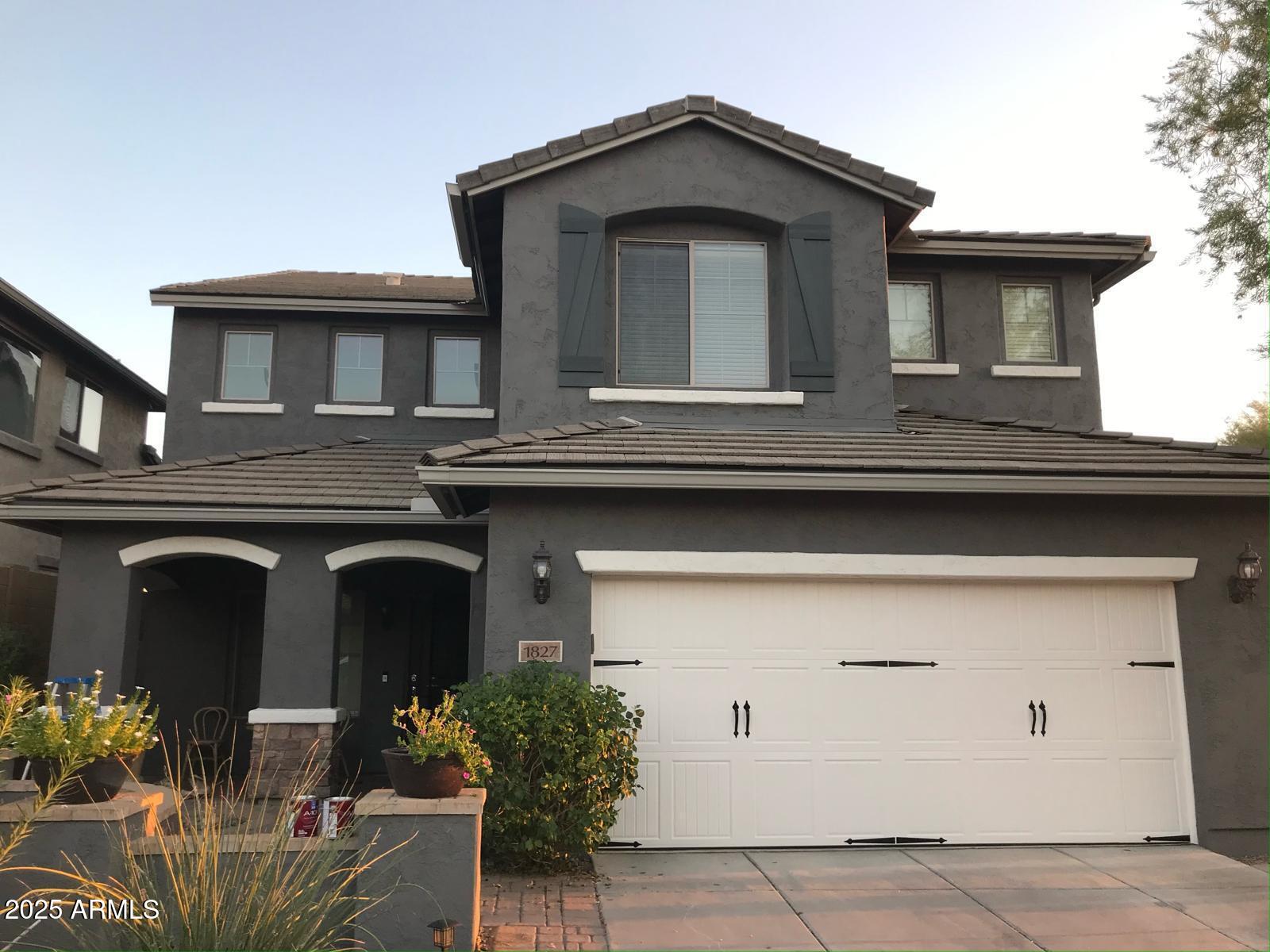 a front view of a house with potted plants