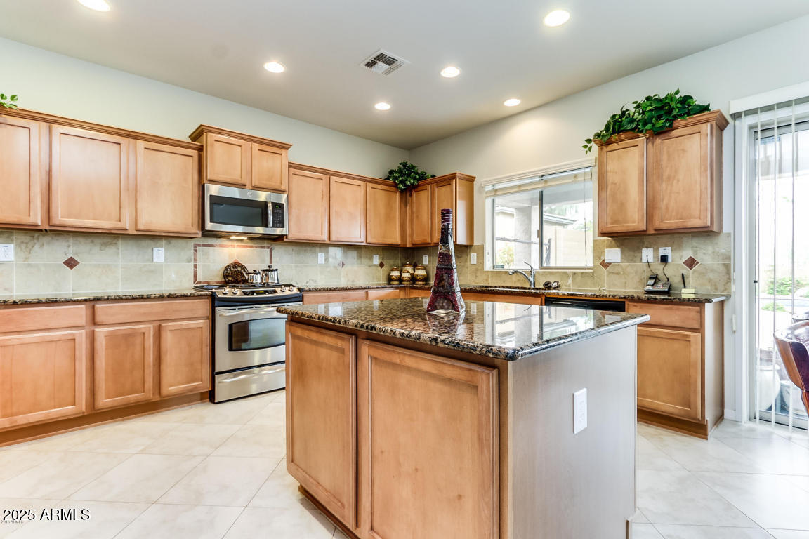 1827 West Black Hill Road Phoenix, AZ 85085 - Photo 17 of 49 a kitchen with kitchen island granite countertop a sink counter top space appliances and cabinets
