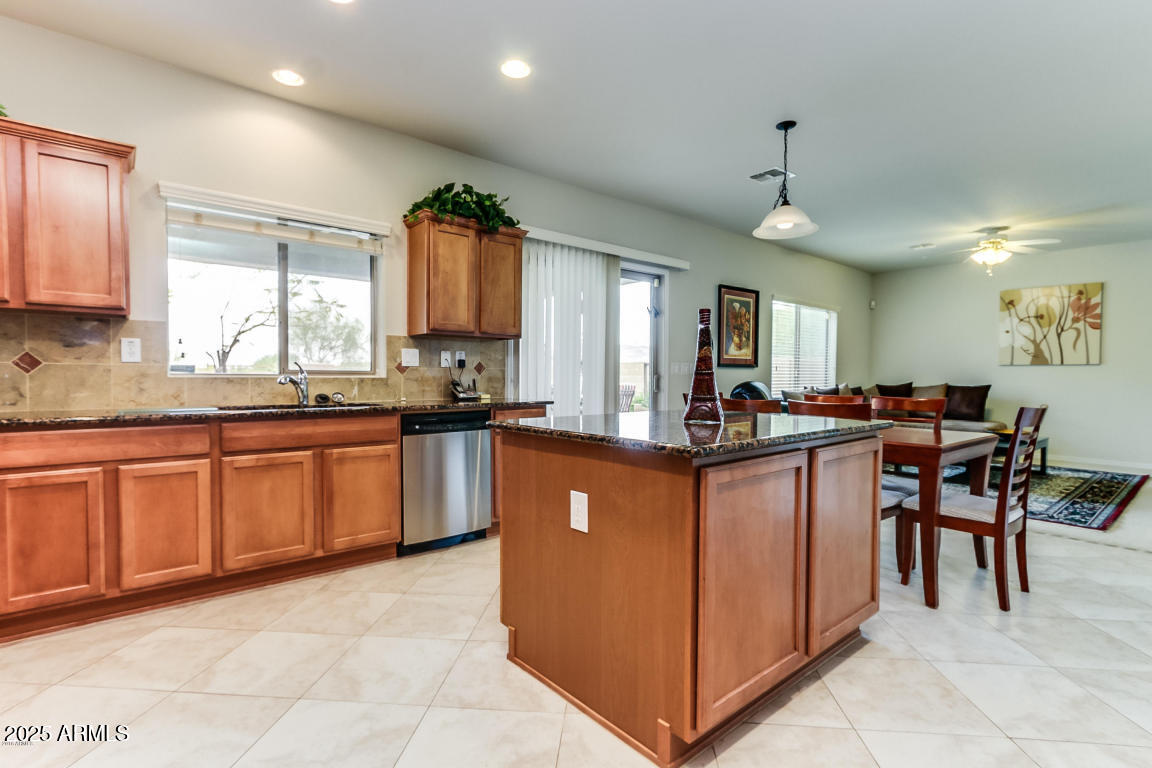 1827 West Black Hill Road Phoenix, AZ 85085 - Photo 20 of 49 a kitchen with stainless steel appliances granite countertop wooden cabinets a sink a stove a counter top space and a window