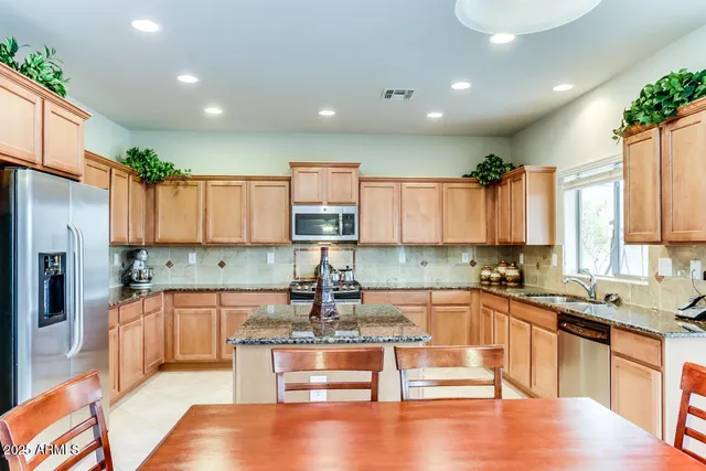 a kitchen with granite countertop stainless steel appliances white cabinets granite counter tops and a wooden floors