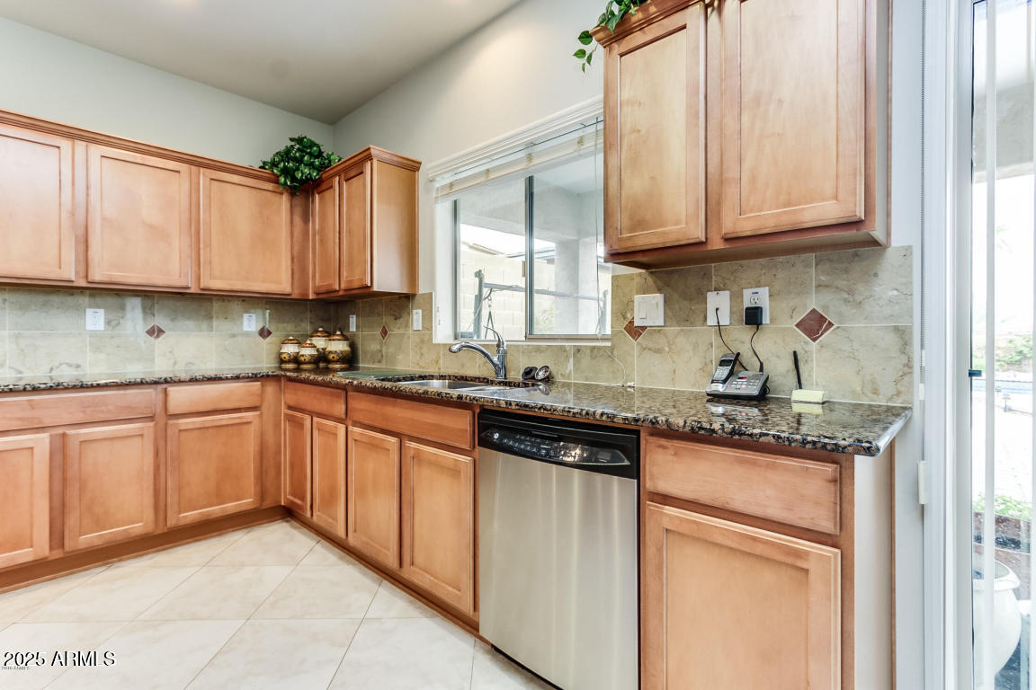 1827 West Black Hill Road Phoenix, AZ 85085 - Photo 22 of 49 a kitchen with stainless steel appliances granite countertop a sink stove and cabinets