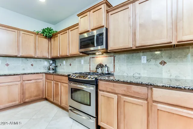 a kitchen with stainless steel appliances granite countertop a stove sink and cabinets