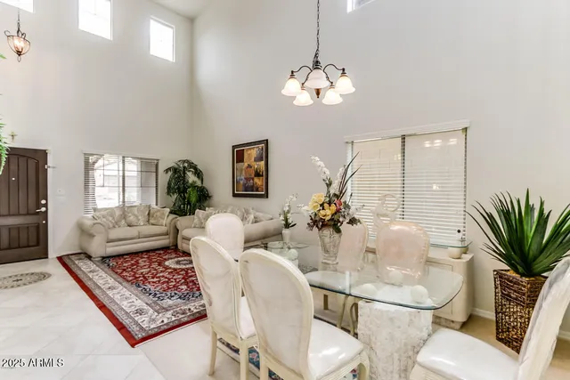 a living room with furniture chandelier and a potted plant