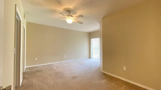 a view of an empty room with a chandelier fan