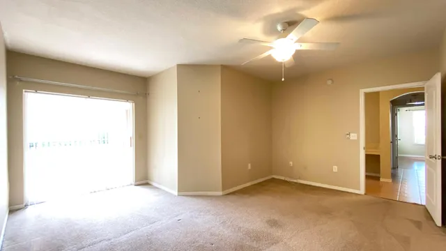 an empty room with fan and entrance