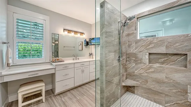 a bathroom with a double vanity sink mirror and shower