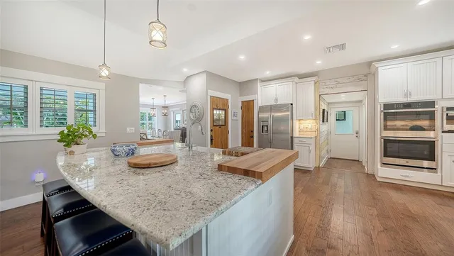 a kitchen with a refrigerator sink and cabinets
