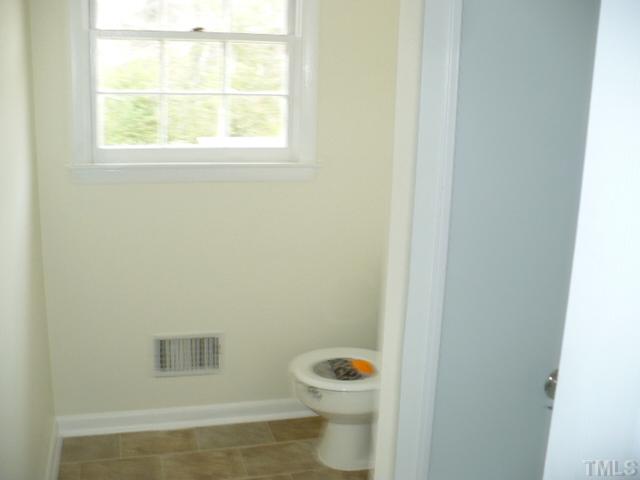 1324 Marlborough Road Raleigh, NC 27610 - Photo 7 of 10 a white toilet sitting next to a bathroom sink and vanity
