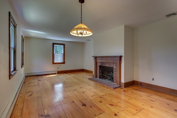 211 Littleton County Road Harvard, MA 01451 - Photo 10 of 30 a view of a livingroom with a fireplace a chandelier and wooden floor