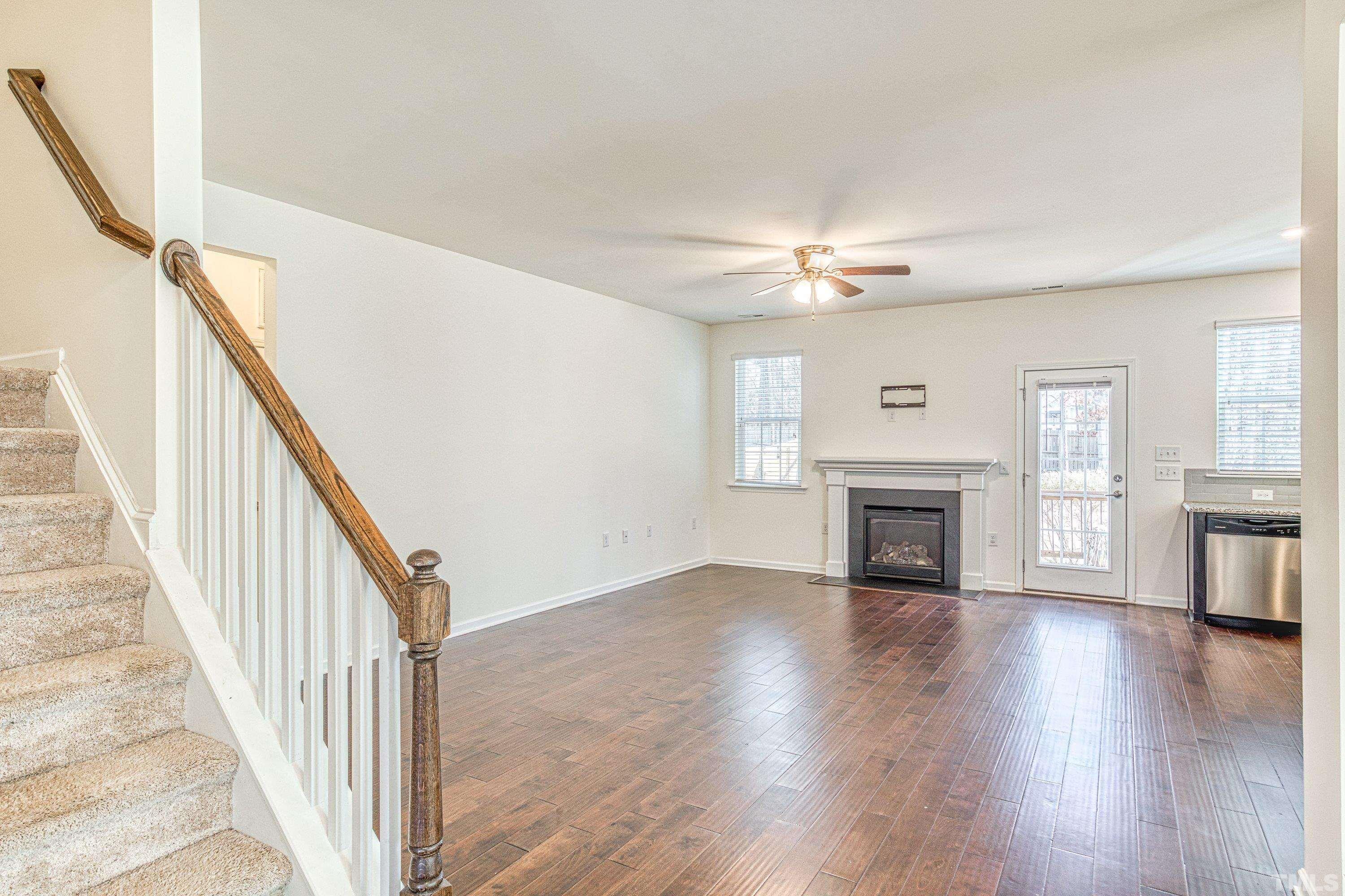 3617 Lily Orchard Way Cary, NC 27518 - Photo 12 of 47 a view of an empty room with wooden floor fireplace and a window