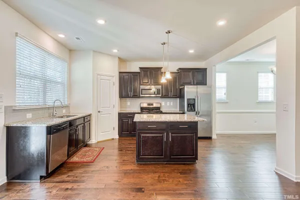 a large kitchen with stainless steel appliances granite countertop a stove and a refrigerator