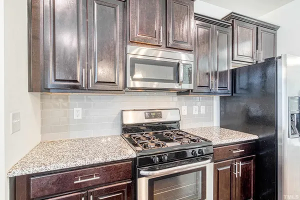 a kitchen with granite countertop cabinets stainless steel appliances and a counter space