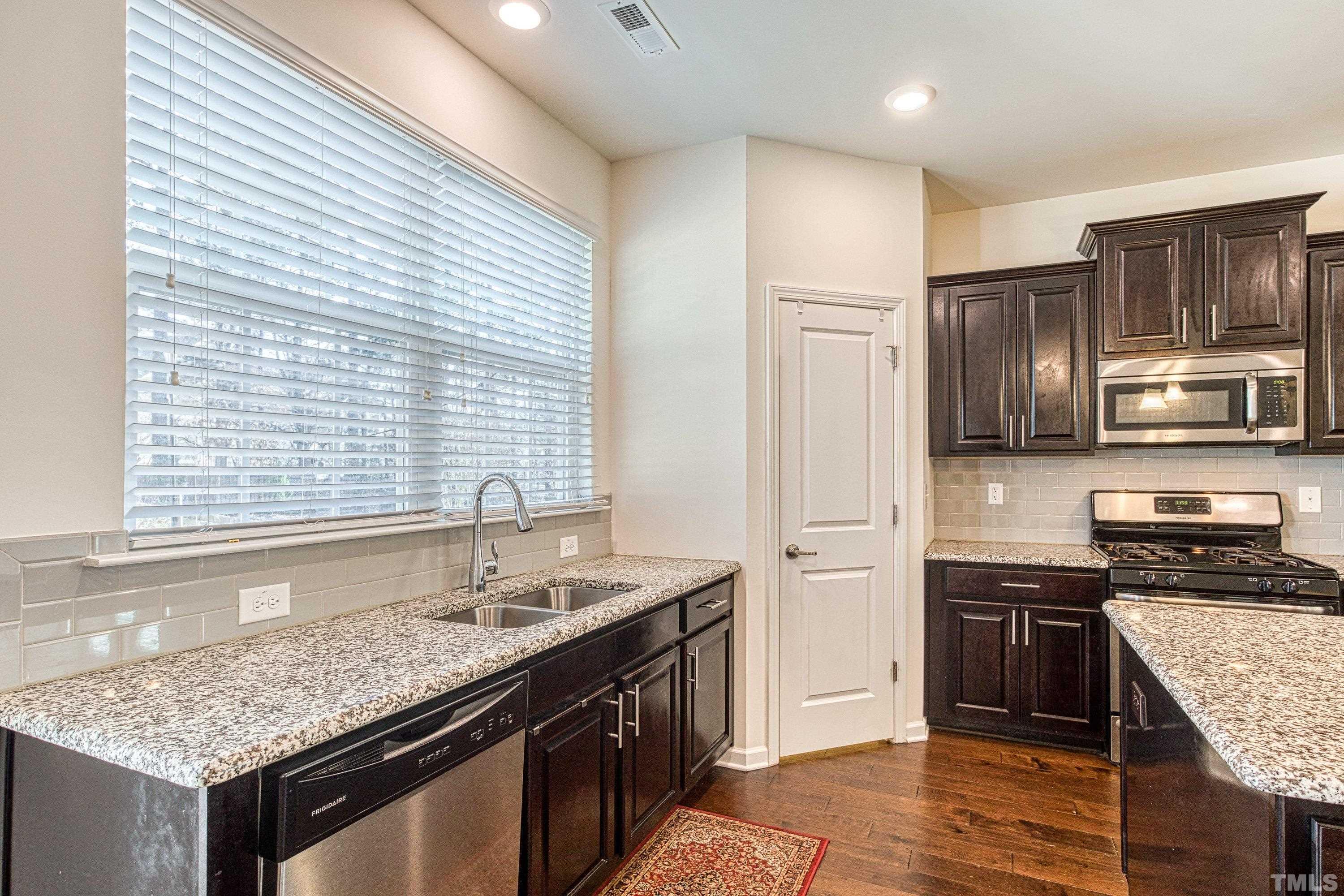 3617 Lily Orchard Way Cary, NC 27518 - Photo 23 of 47 a kitchen with stainless steel appliances granite countertop a sink stove and refrigerator