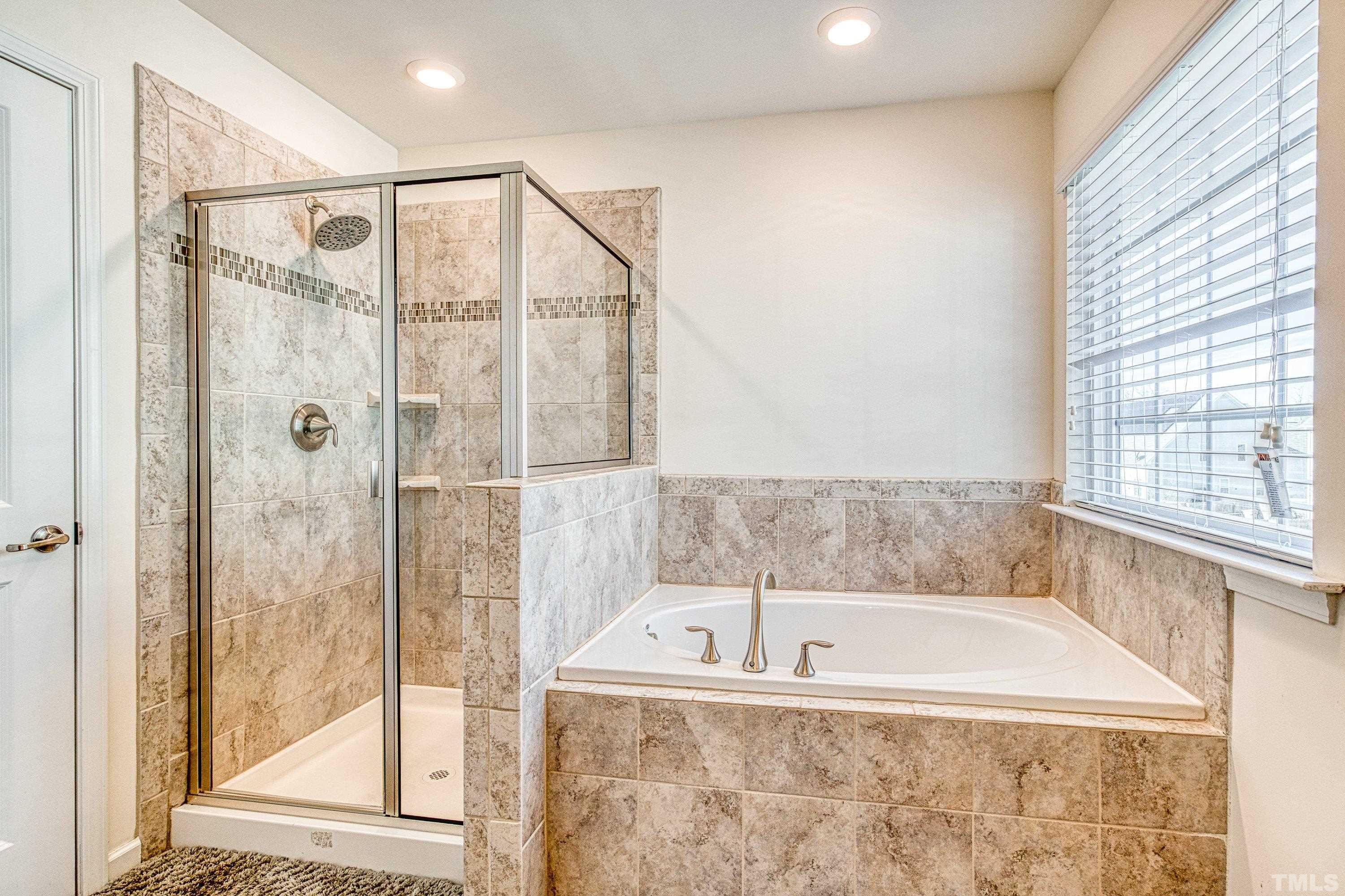 3617 Lily Orchard Way Cary, NC 27518 - Photo 35 of 47 a bathroom with a bathtub and a shower