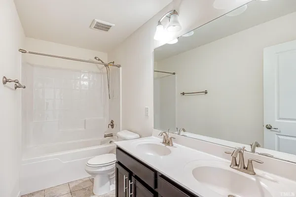 a bathroom with a granite countertop sink toilet mirror and shower