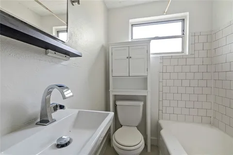 a bathroom with a sink a toilet and bathtub