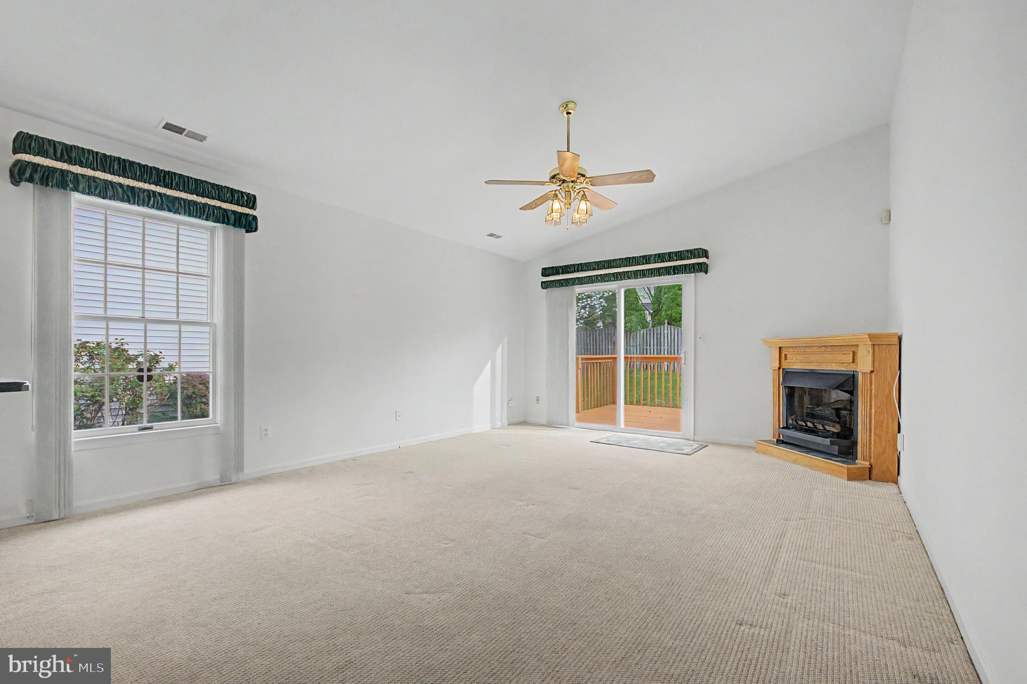 795 Eastern Point Road Annapolis, MD 21401 - Photo 7 of 38 an empty room with windows and chandelier fan