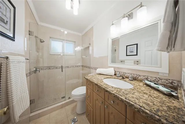 a bathroom with a granite countertop sink a mirror and shower