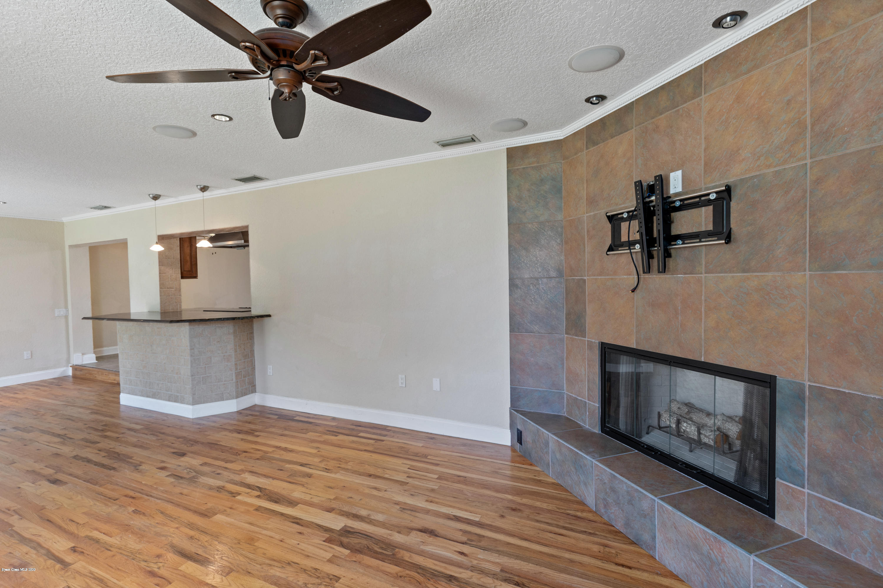 839 Knecht Road Northeast Palm Bay, FL 32905 - Photo 13 of 37 a view of an empty room with wooden floor and a fireplace