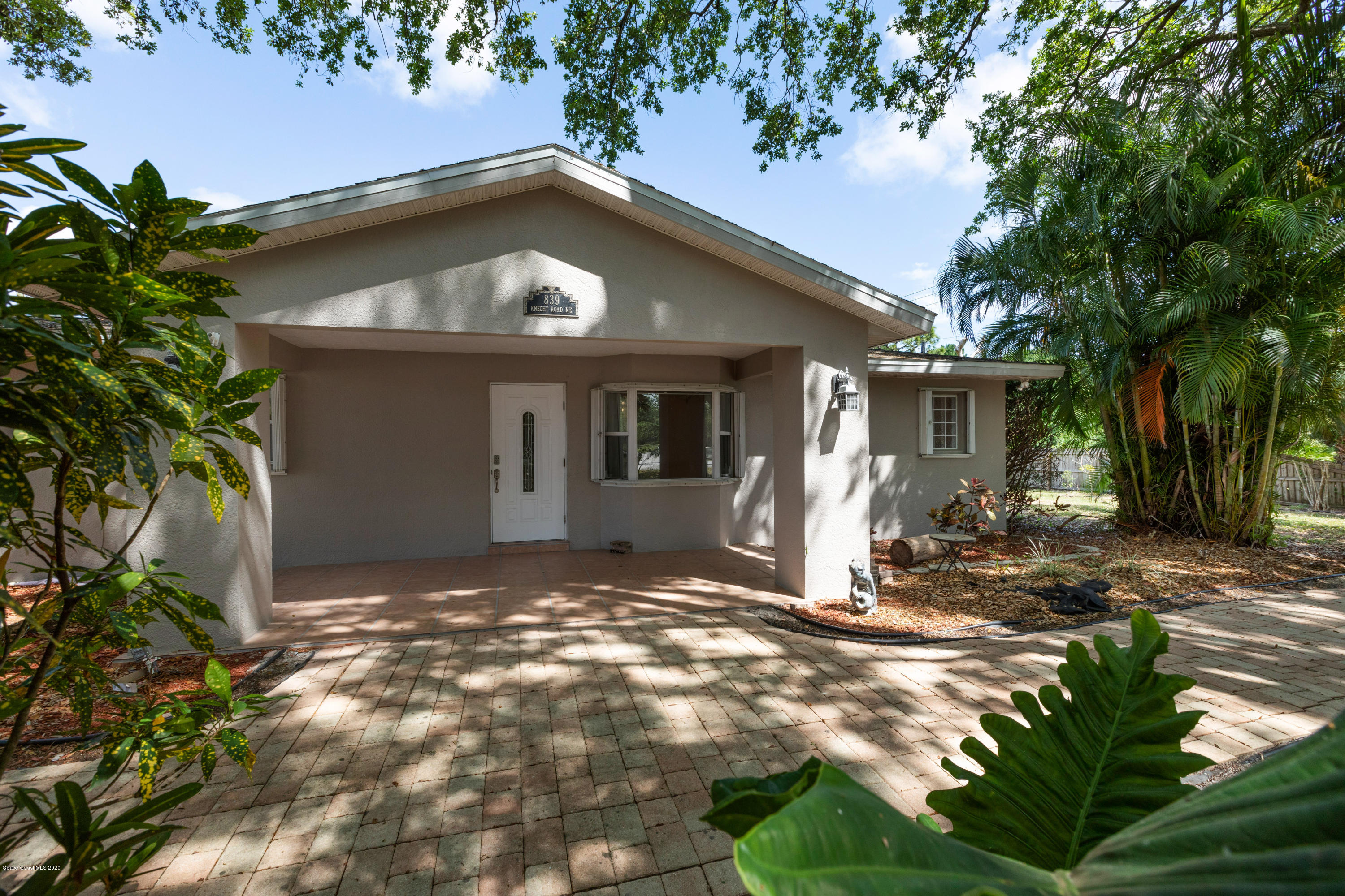 839 Knecht Road Northeast Palm Bay, FL 32905 - Photo 3 of 37 a view of a house with small yard plants and a large tree