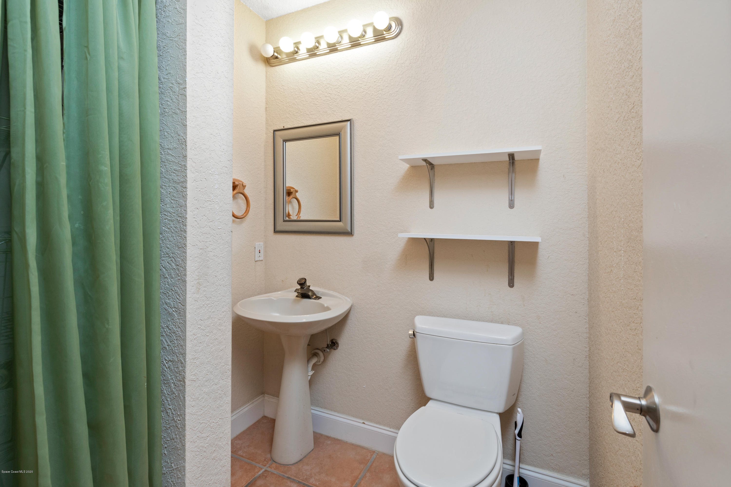 839 Knecht Road Northeast Palm Bay, FL 32905 - Photo 32 of 37 a bathroom with a toilet a sink and mirror
