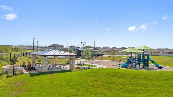 a view of a patio with table and chairs under an umbrella with a big yard