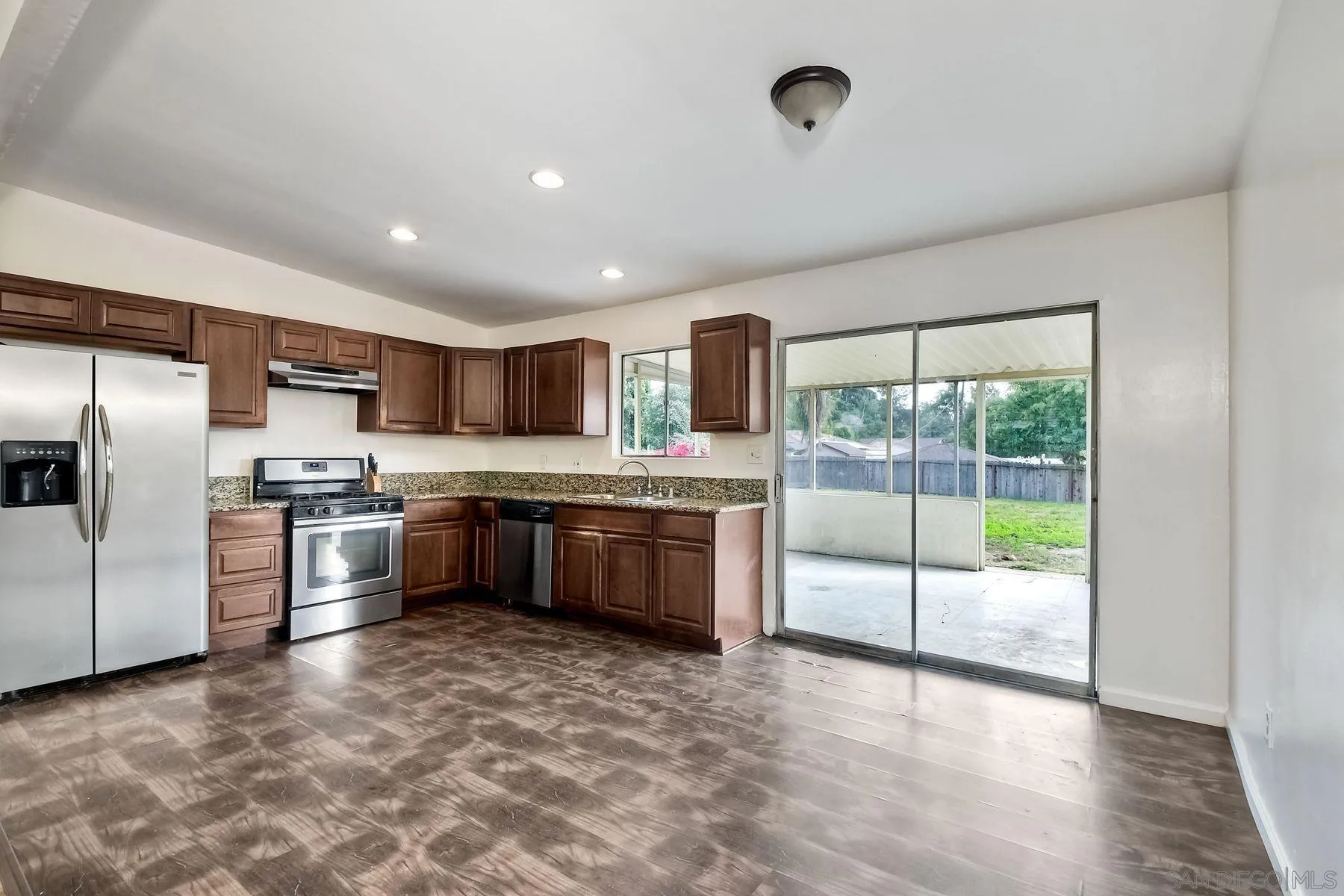 1220 Bluegrass Road Vista, CA 92083 - Photo 7 of 25 a modern kitchen with stainless steel appliances granite countertop a stove a sink and a refrigerator