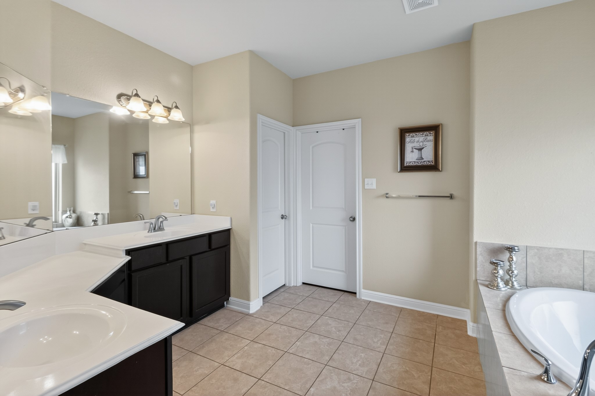 24711 East Burnaby Circle Spring, TX 77373 - Photo 12 of 20 a spacious bathroom with a double vanity sink a mirror and a bathtub