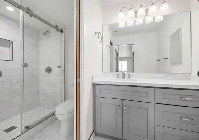 a bathroom with a sink a toilet and shower