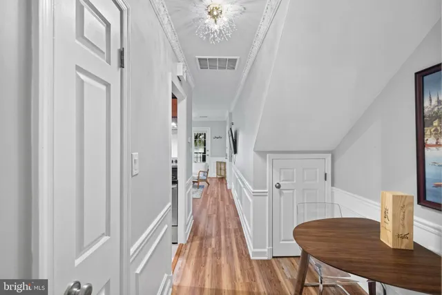 a view of a hallway with furniture and wooden floor