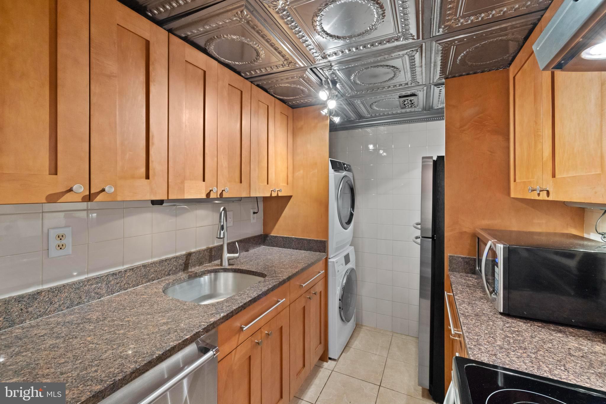4613 MacArthur Boulevard Northwest, Unit A Washington, DC 20007 - Photo 9 of 21 a kitchen with a sink a counter top space cabinets and stainless steel appliances