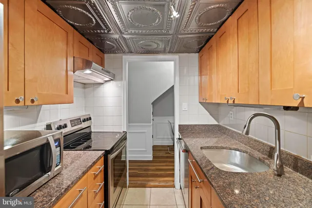 a kitchen with granite countertop a stove a sink and dishwasher