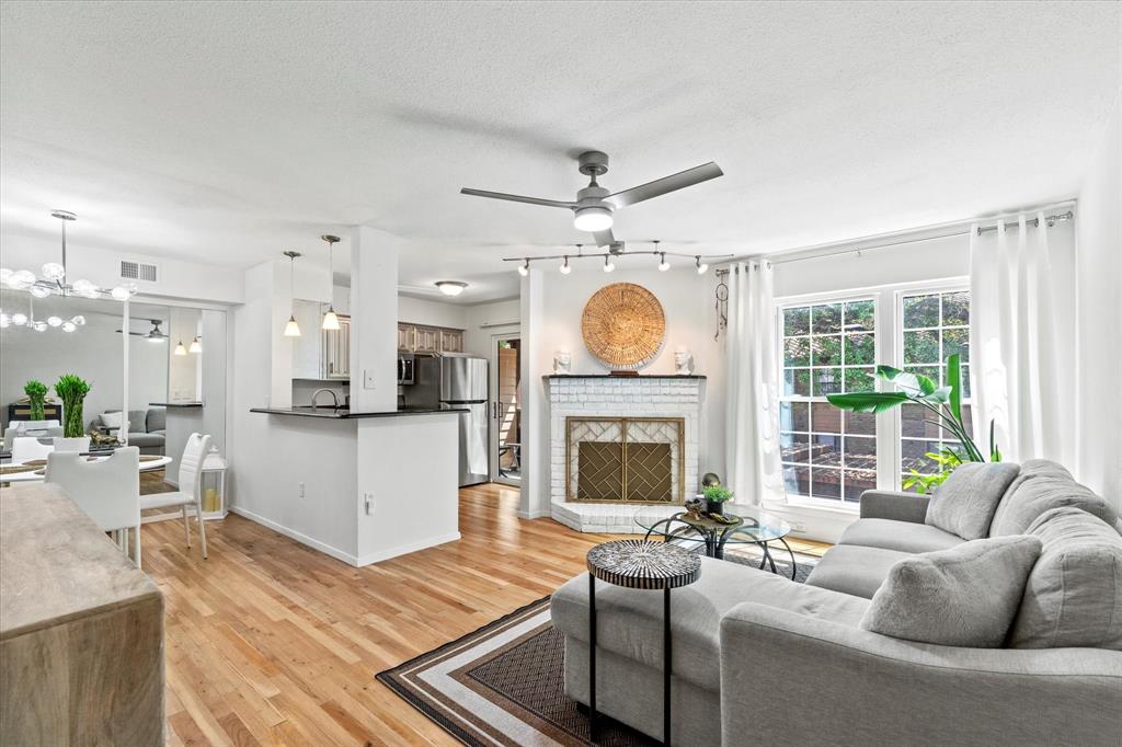 a living room with furniture a fireplace and a large window