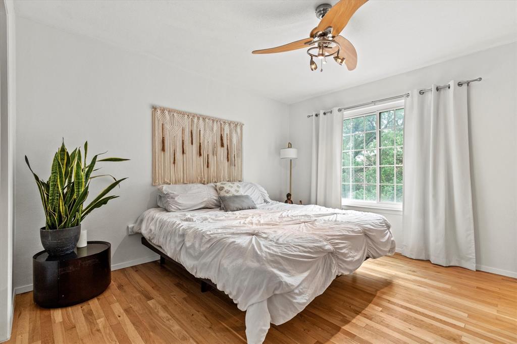 5626 Preston Oaks Road, Unit 51D Dallas, TX 75254 - Photo 15 of 19 a bedroom with a bed and a chandelier