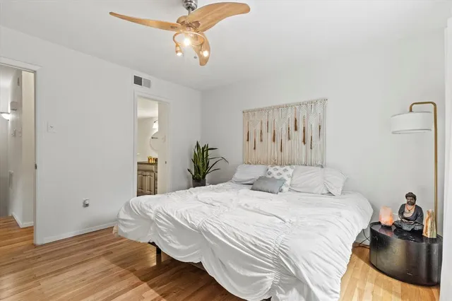 a bedroom with a bed and wooden floor